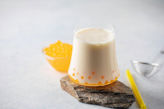 Cold iced fruit bubble tea with juice balls in glass