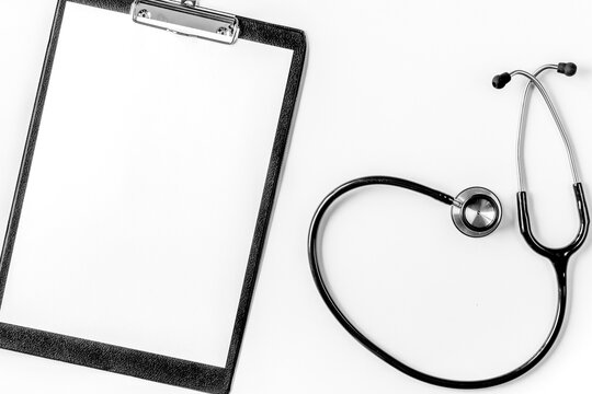doctor's work desk in hospital with notepad and stethoscope white background top view mockup