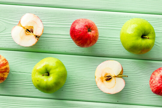 Red apples pattern on green wooden background top view