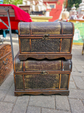 Decorative vintage wooden treasure chests at an outdoor flea market in a sunny location