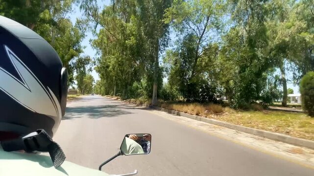 Motorcycle Ride on Khanpur dam road in pakistan with Scenic Roadside View, showing the road, roadside trees, motorcycle mirror and helmet during a scenic journey toward Naran Kaghan. Travel and road,