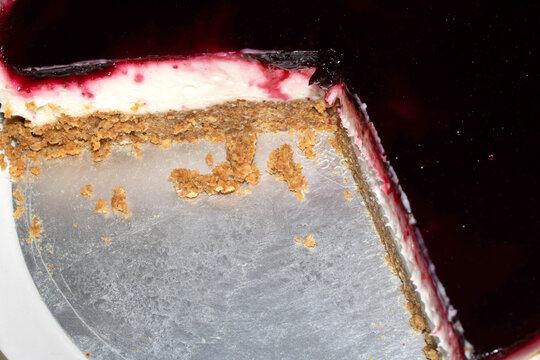 Home made blackberry vegan cheesecake dessert sliced to see the biscuit base