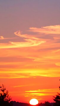 Deep orange sunset sky with glowing sun at horizon