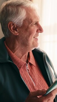 Online, tablet and old man in home with laugh, funny news update and notification for social media. Happy, senior person and relax by window with tech, internet meme or thinking of text message joke.