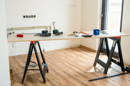 Workbench equipped with various power tools, measuring instruments, and materials during a home renovation. 