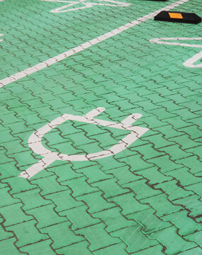 Electric vehicle charging station parking space green paving symbol