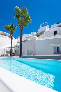 White architecture against the blue sky in Santorini island, Greece. Luxury swimming pool with blue water.