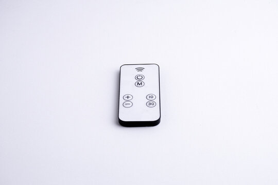 Modern white remote control isolated on white background flat lay and top view