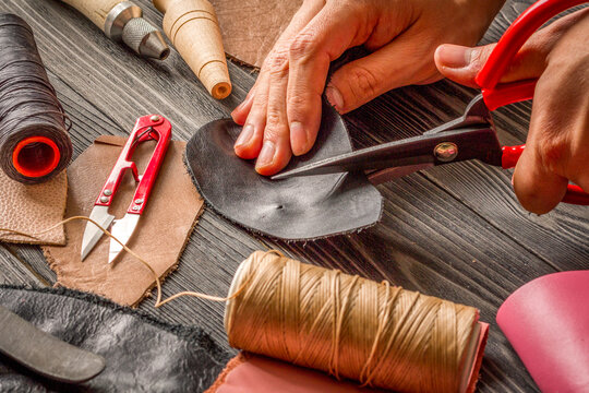 work in leather shop on dark wooden background close up