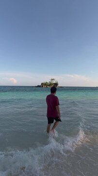 Man Walking on Tropical Beach at Sunset