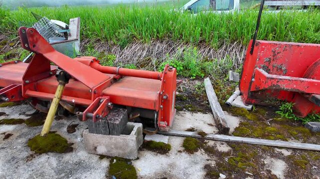 Agricultural tractor implements including tiller and snow blower on a farm