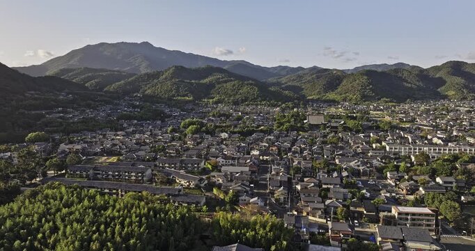 Kyoto Japan Aerial v40 flyover across Saganonomiyacho in Ukyo Ward, revealing homes, cultivated fields and layered mountains during golden hour - Shot with Mavic 3 Pro Cine - Oct 7th 2023