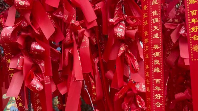 Red ribbons hang from a display during a festival in an Asian market celebrating good fortune and happiness