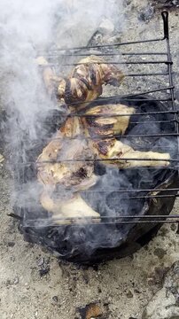 Whole Chicken Grilling Over Charcoal Outdoors