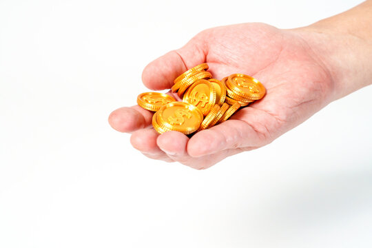 Hand holding a pile of golden dollar coins isolated on white background. Concept of financial wealth, profit, investment and savings. Professional studio shot with clean copy space.