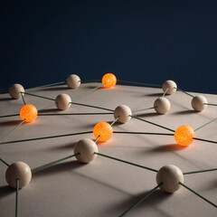 Obraz premium Network structure of wooden spheres and connecting rods with glowing orange active nodes. Physical metaphor for neural networks and data transmission. Complex technological system concept