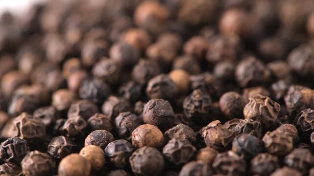 Whole black peppercorns filling the frame close up macro
