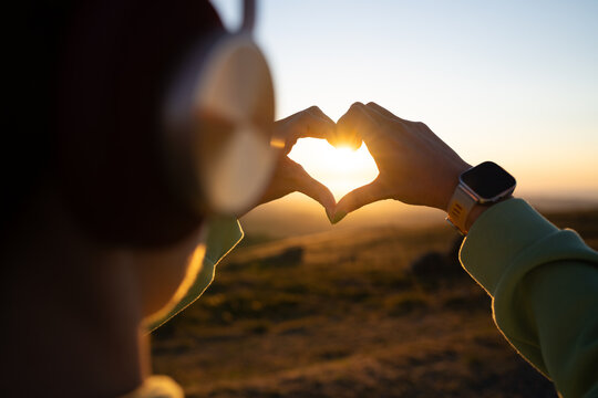 White Person forming heart shape with hands at sunset in Galicia Spain