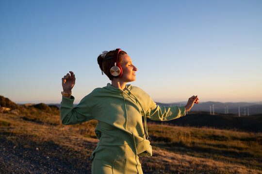 White Woman enjoying music and dancing outdoors at sunset in Galicia