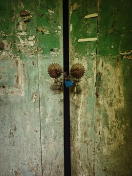 Overgrown abandoned courtyard and rusty iron gate in a Chinese county town.