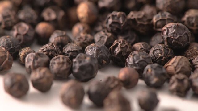 Whole black peppercorns filling the frame close up macro
