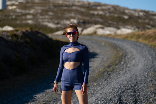 A white woman stands outdoors on a gravel trail in Galicia, Spain