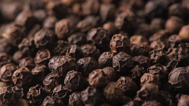 Whole black peppercorns filling the frame close up macro