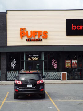 Gatineau, Quebec, Canada &ndash; June 13, 2026: A modern commercial storefront features an orange "Mr. Puffs" Bar &agrave; desserts sign above glass windows with an ouvert sign at 571 Chemin Vanier.