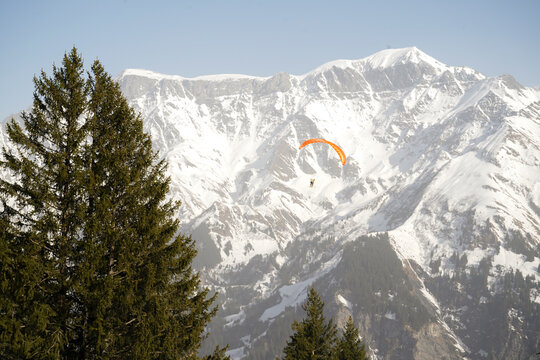 snow covered mountains with paraglider