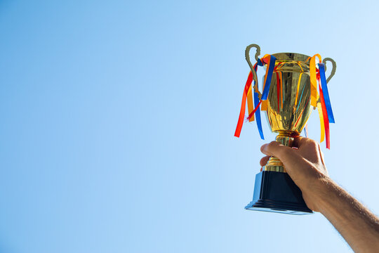 Man holding a winner golden trophy cup.