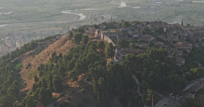Berat Albania Aerial v9 zoomed 3x birds eye orbit around Berat Castle, capturing fortified hilltop walls and historic residences at sunset - Shot with Mavic 3 Pro Cine - July 11th 2024