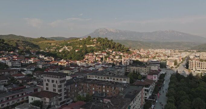 Berat Albania Aerial v15 low flyover above downtown residential blocks, capturing dense cityscape, surrounding hillsides and mountains at sunset - Shot with Mavic 3 Pro Cine - July 11th 2024
