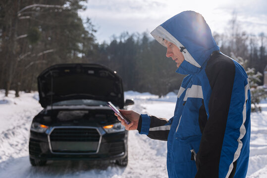 Driver call roadside assistance for winter car breakdown