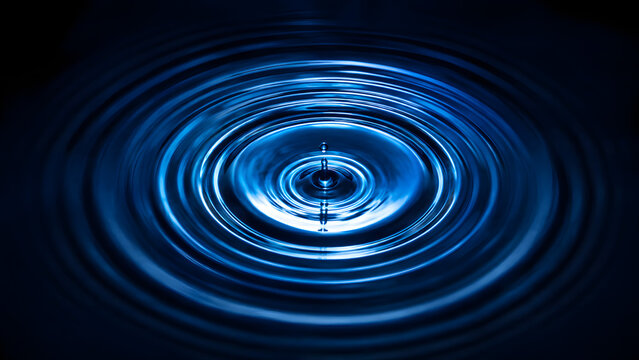 Ripples forming in water after a drop falls into a still surface Generative AI