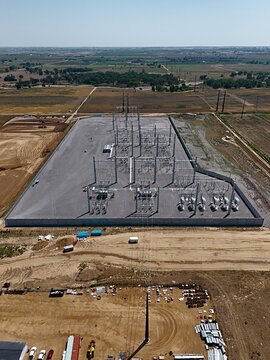 Aerial view of Fort St. Vrain Generating Station with electrical transformers and power lines in a fenced compound surrounded by rural fields in Platteville, Colorado, United States.