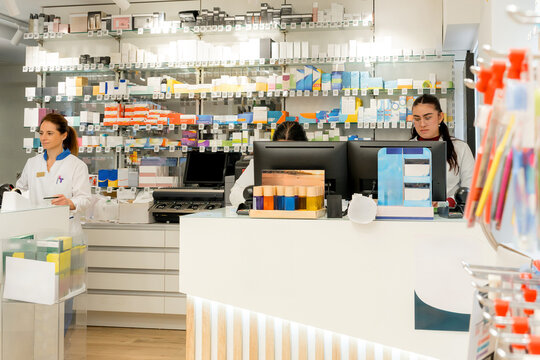 Pharmacist staff serving customers at modern pharmacy counter