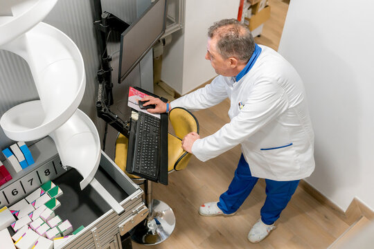 Pharmacist operate medicine dispensing machine in pharmacy
