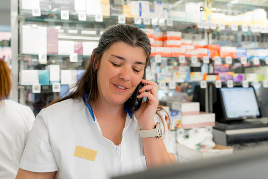 Pharmacist answer phone call at pharmacy counter