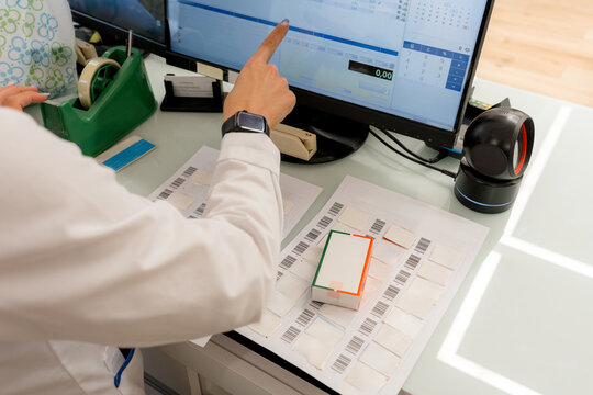 Pharmacist scan medicine barcode at pharmacy computer workstation