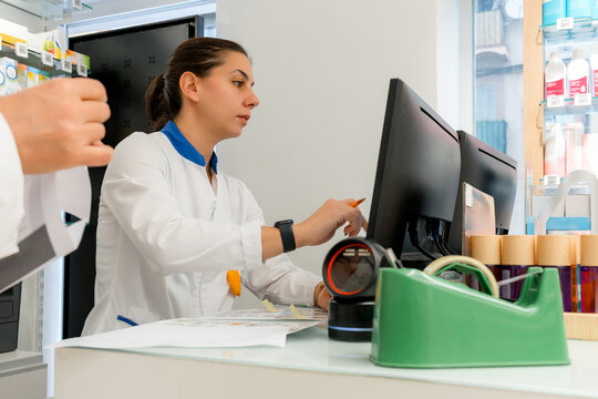 Pharmacist use computer at pharmacy counter