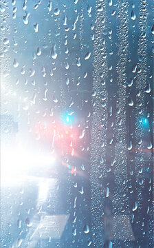 Wet car glass, autumn rain on the road, drops on the glass