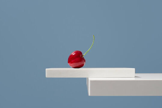 Jerte cherry on white pedestal against blue background