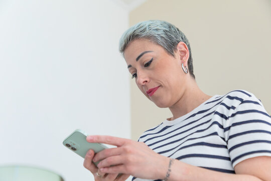Professional esthetician using smartphone in skincare clinic