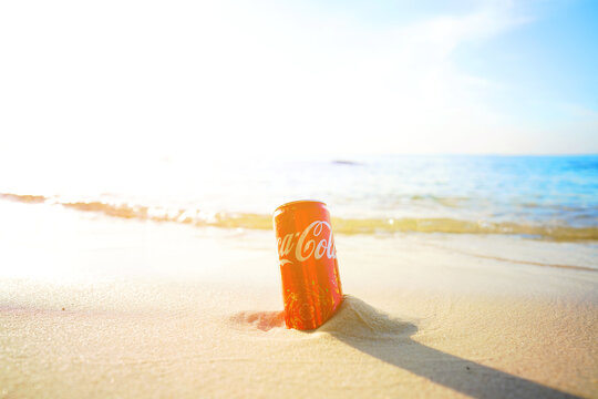 Coca-Cola can found on beach on sunset by sea near quiet waves. Cold Coca-Cola can sits in sand on beach as waves gently lap at shore. Crumpled soda can on sand beach at sea. Jan 2, 2026, Vietnam.