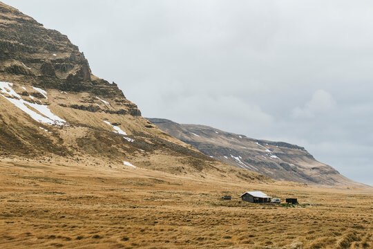 Remote cabin beneath snow-dusted mountains in Iceland