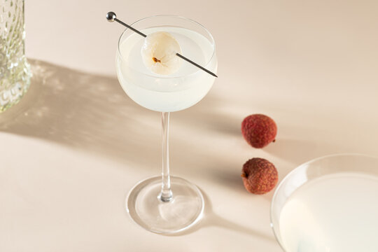 Lychee cocktail in coupe glass with fresh fruit garnish