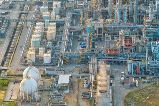 Aerial view of an industrial chemical plant featuring numerous storage tanks, spherical gas containers, complex pipeline networks, and cooling towers in Bantzenheim, Grand Est, France.