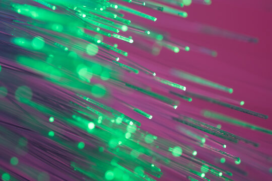 Green fiber optic strands on magenta tech background