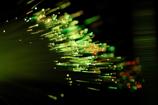 Green fiber optic cable strands with glowing data light