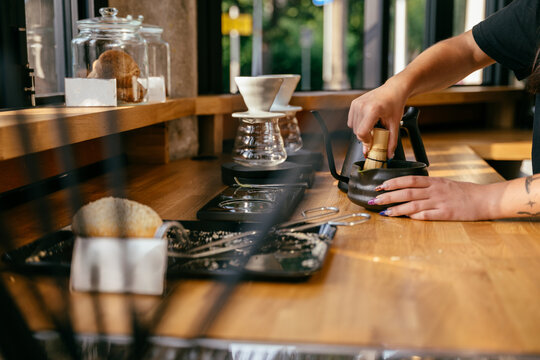 Professional barista preparing traditional matcha tea with bamboo whisk at specialty cafe counter